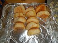 several pieces of very dry looking bread in a single use aluminium pan