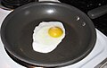 a lone fried egg with no seasoning in a pan